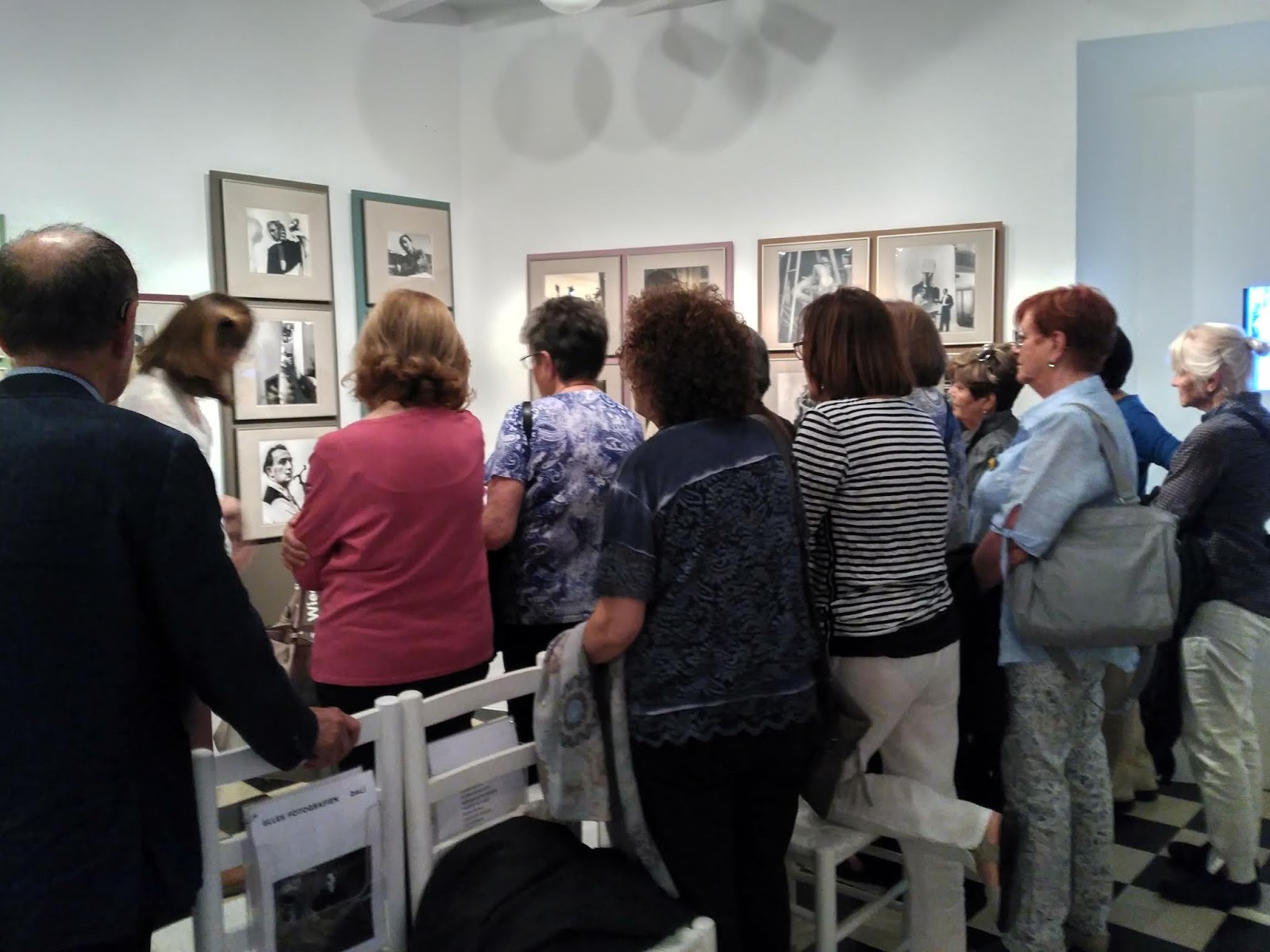 Bea Crespo explicant l'exposició envoltada de socis dels Amics